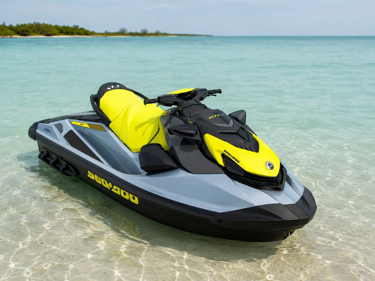A yellow jet ski resting on calm, clear turquoise water.